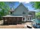 Back of home features screened in porch, paver patio, lush greenery, and mature trees at 2009 Westside Ln, Woodstock, GA 30189