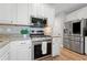 Gourmet kitchen features granite countertops, stainless steel appliances, and white cabinetry at 2009 Westside Ln, Woodstock, GA 30189