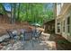 Paver patio with seating area around fire pit, lush greenery, privacy fence, and screened in porch at 2009 Westside Ln, Woodstock, GA 30189
