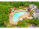 Aerial view of a uniquely shaped community pool with lounge chairs, umbrellas, and lush landscaping at 2009 Westside Ln, Woodstock, GA 30189