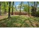View of brick home's backyard featuring mature trees and greenery for a private and peaceful setting at 5935 Christopher Ln, Lithonia, GA 30058