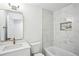 Updated bathroom with a large mirror, tub, marble tiling, and gold fixtures at 5935 Christopher Ln, Lithonia, GA 30058