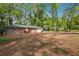 A single story brick home with red shutters and two car garage surrounded by mature trees at 5935 Christopher Ln, Lithonia, GA 30058
