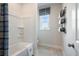 Bathroom showcasing a tub with a shower, decorative shower curtain, window and wall rack with storage baskets at 6180 Misty Hill Ln, Buford, GA 30518