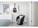 The bedroom features a black and white chair, guitar decorations, and a dresser topped with a lamp at 6180 Misty Hill Ln, Buford, GA 30518
