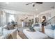 Open-concept living room with large windows, plush seating, and a modern kitchen at 6180 Misty Hill Ln, Buford, GA 30518