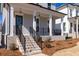 Inviting front porch with brick stairs, black railing, and classic columns, creating a welcoming entryway at 171 Basil Street Dr, Cumming, GA 30040