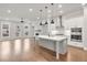 Bright, open-concept kitchen featuring a large island, stainless steel appliances, and hardwood flooring at 171 Basil Street Dr, Cumming, GA 30040
