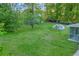 Green backyard showing lush lawn and mature trees. A great outdoor space to relax and unwind at 2027 Kensington High Sw St, Lilburn, GA 30047