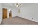 Spacious bedroom with neutral carpet, ceiling fan, and a view to the ensuite bathroom at 2027 Kensington High Sw St, Lilburn, GA 30047