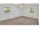 Bright bedroom with neutral carpet, ceiling fan, and plenty of natural light from two windows at 2027 Kensington High Sw St, Lilburn, GA 30047