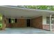 Attached brick carport with direct access to the house, providing sheltered parking at 2027 Kensington High Sw St, Lilburn, GA 30047