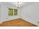 Bright dining room features hardwood floors, a large window, and classic chandelier at 2027 Kensington High Sw St, Lilburn, GA 30047