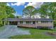 Inviting brick home featuring a convenient carport and a quaint front porch at 2027 Kensington High Sw St, Lilburn, GA 30047