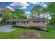 Classic brick home with a carport and covered front porch, surrounded by mature trees at 2027 Kensington High Sw St, Lilburn, GA 30047