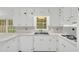 Bright white kitchen features modern appliances, plentiful storage, and backyard view at 2027 Kensington High Sw St, Lilburn, GA 30047