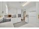 Well-lit kitchen features all white cabinets, grey tile floor, and stainless steel appliances at 2027 Kensington High Sw St, Lilburn, GA 30047