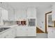 Well-lit kitchen with white cabinets, stainless appliances, and view to another room at 2027 Kensington High Sw St, Lilburn, GA 30047