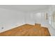 Clean living room with hardwood flooring, white walls, and lots of natural light at 2027 Kensington High Sw St, Lilburn, GA 30047