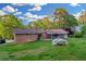 A lush green backyard with a well-maintained lawn and a view of the brick house with a screened-in porch at 2027 Kensington High Sw St, Lilburn, GA 30047