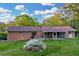 Expansive backyard featuring a brick house with a screened porch and a flourishing flower bush at 2027 Kensington High Sw St, Lilburn, GA 30047