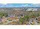 A high-angle aerial view shows a mature neighborhood filled with trees and well-maintained homes under a blue and cloudy sky at 2195 Brickton Sta, Buford, GA 30518