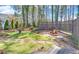 A backyard features a stone fountain and a fire pit surrounded by lattice fencing and meticulous landscaping at 2195 Brickton Sta, Buford, GA 30518