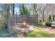An outdoor space has a brick-lined fire pit surrounded by lattice fencing and meticulous landscaping at 2195 Brickton Sta, Buford, GA 30518