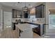 Modern kitchen with dark cabinets, a light island, stainless steel appliances and white backsplash at 2195 Brickton Sta, Buford, GA 30518