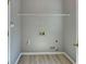 Bright laundry room with gray walls, light wood-look floors, and washer/dryer hookups at 2195 Brickton Sta, Buford, GA 30518