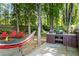 Backyard with patio and built-in grill, complemented by a cozy firepit and hammock amid serene trees at 2801 Livsey Dr, Tucker, GA 30084
