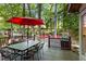 A wooden deck with an umbrella and chairs overlooking a lush backyard that is perfect for relaxation at 2801 Livsey Dr, Tucker, GA 30084
