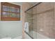 Shower and tub area with tiled walls and sliding glass doors and a window with woven shades at 2801 Livsey Dr, Tucker, GA 30084