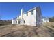 Angle shot of back exterior, including a chimney, siding, and a small patio at 484 Charleston Pl, Villa Rica, GA 30180