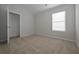 This bedroom has neutral walls, carpet flooring, and a window for natural lighting at 484 Charleston Pl, Villa Rica, GA 30180