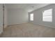 This bedroom has neutral walls and carpet flooring, with windows for natural light at 484 Charleston Pl, Villa Rica, GA 30180