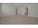 This bedroom has neutral walls and carpet flooring, with open doors leading to other rooms at 484 Charleston Pl, Villa Rica, GA 30180
