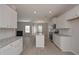 Open kitchen layout with a large granite island, stainless appliances and white cabinets at 484 Charleston Pl, Villa Rica, GA 30180