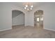 Inviting open-concept dining room with wood floors and archway to a large kitchen and staircase at 484 Charleston Pl, Villa Rica, GA 30180