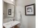 Elegant half bathroom with pedestal sink, decorative mirror and artwork at 1005 Milhaven Dr, Roswell, GA 30076
