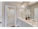 Well-lit bathroom showcasing a double vanity, large mirror, white cabinets, and a shower-tub combo at 1005 Milhaven Dr, Roswell, GA 30076