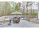 Back deck features an umbrella-covered table beside a fenced in-ground pool and forested backyard at 1484 W Prospect Dr, Lawrenceville, GA 30043