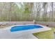 Inviting in-ground pool in a fenced backyard surrounded by trees, with minimal grass at 1484 W Prospect Dr, Lawrenceville, GA 30043