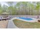 Backyard with an in-ground pool, a deck and lounge chairs surrounded by a wooded area at 1484 W Prospect Dr, Lawrenceville, GA 30043