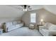 Comfortable bedroom with neutral carpet, a white sofa, a window, and a side table with reading lamp at 1484 W Prospect Dr, Lawrenceville, GA 30043
