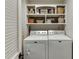 Functional laundry room with matching washer and dryer and shelving for storage and organization at 1484 W Prospect Dr, Lawrenceville, GA 30043
