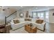 Bright living room boasts hardwood floors, a large white sofa, and access to the stairway and dining area at 1484 W Prospect Dr, Lawrenceville, GA 30043