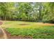 The outdoor greenspace features lush grass, trees and a bench creating a beautiful park setting at 3201 Lenox Ne Rd # 22, Atlanta, GA 30324