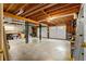 Large basement with unfinished concrete floors, white garage doors and utility sink at 480 Springs End Ne Ln, Marietta, GA 30068