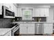 Updated kitchen showcasing white cabinets, stainless appliances, and dark tile backsplash at 480 Springs End Ne Ln, Marietta, GA 30068